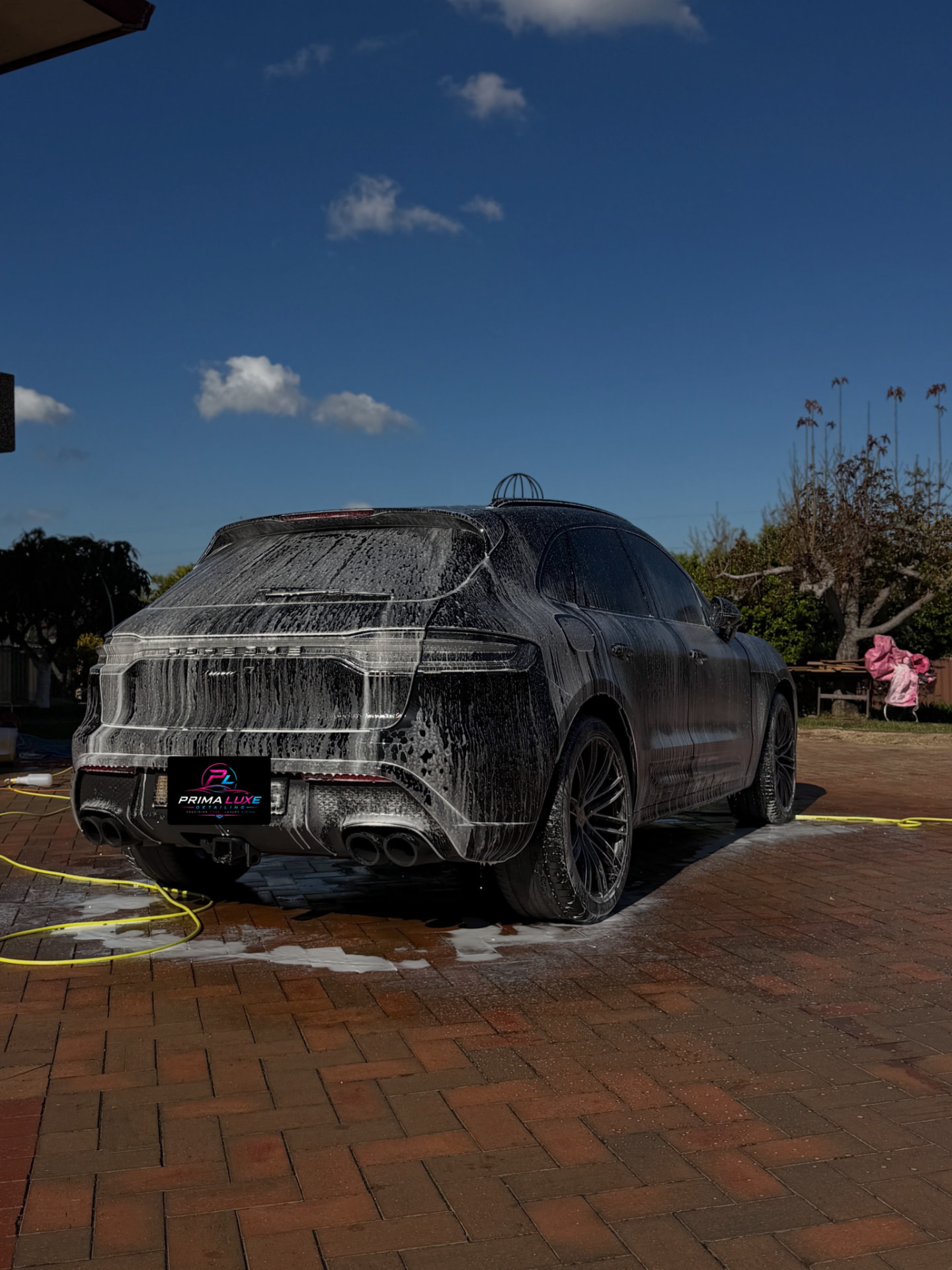 Porsche Macan covered in thick foam during a mobile detail wash